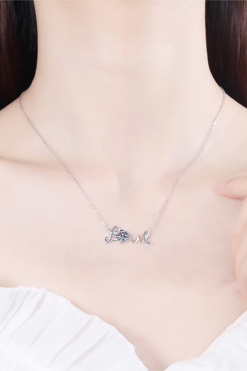 a woman wearing a necklace with the word love on it