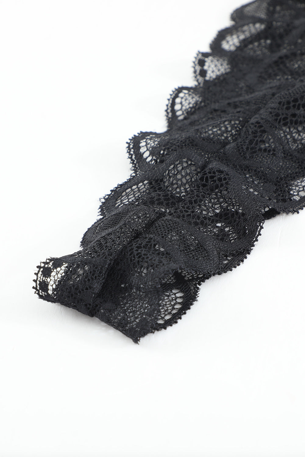 a piece of black lace on a white surface